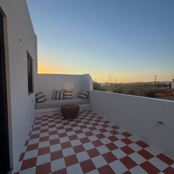 Private terrace with red-and-white checkerboard tiles and built-in bench at sunset, Bluewaves Antiparos Sunstone Terrace House