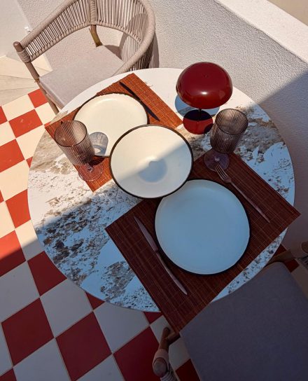 A round table laid for two on the checkered floor