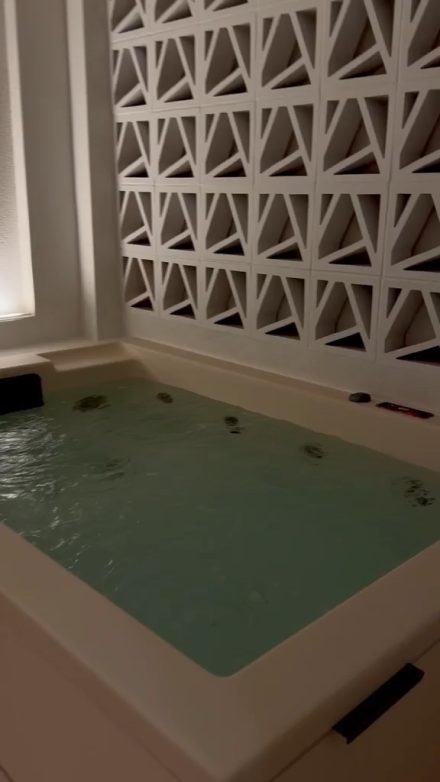 The filled outdoor jacuzzi beside the lattice screen