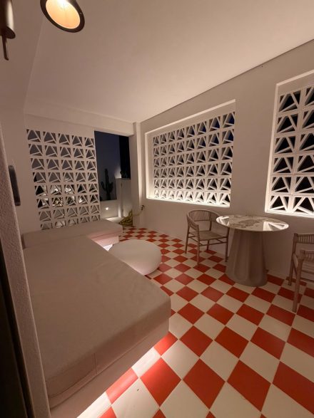 The living area with carved lattice screens and red-and-white checkered floor