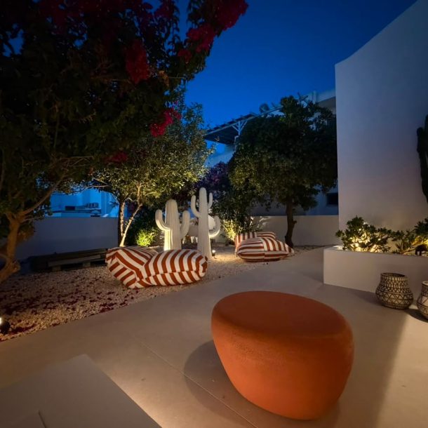 Illuminated private garden with bougainvillea, cactus sculptures and striped loungers at Bluewaves Antiparos Moonstone Jacuzzi House