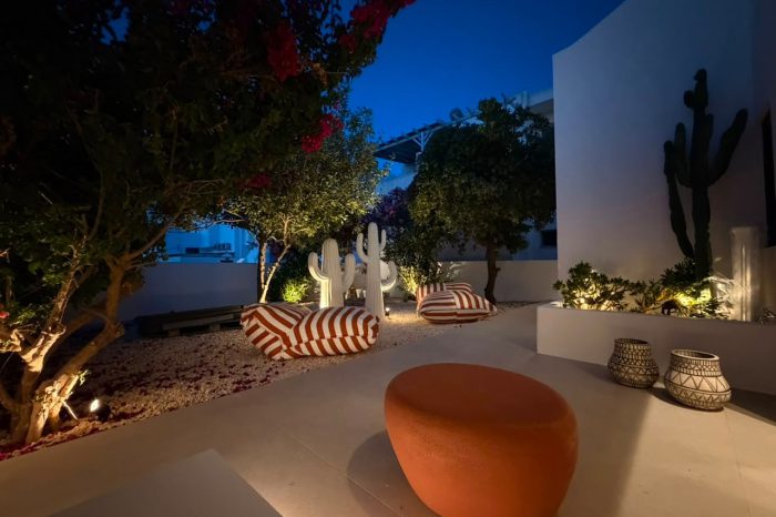 Illuminated private garden with bougainvillea, cactus sculptures and striped loungers at Bluewaves Antiparos Moonstone Jacuzzi House
