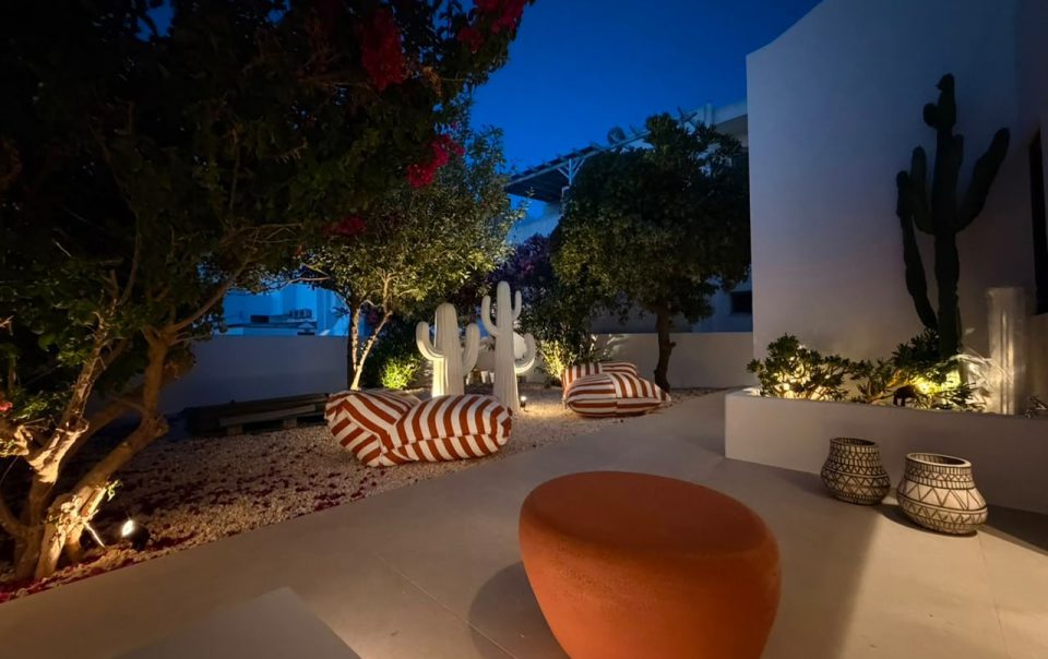 Illuminated private garden with bougainvillea, cactus sculptures and striped loungers at Bluewaves Antiparos Moonstone Jacuzzi House